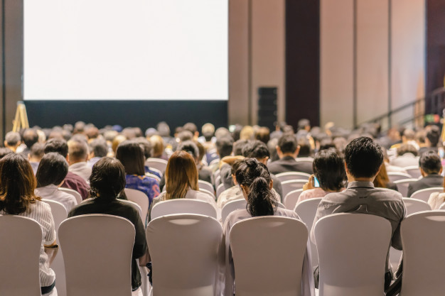 rear-view-audience-listening-speakers-stage-conference-hall-seminar-meeting_41418-3412
